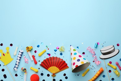 Flat lay composition with carnival items on light blue background. Space for text