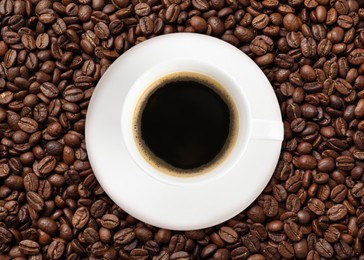 Image of Cup of tasty espresso and roasted coffee beans, top view