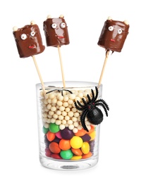 Delicious candies decorated as monsters on white background. Halloween treat