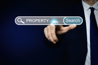 Property search concept. Man using virtual screen with search bar, closeup