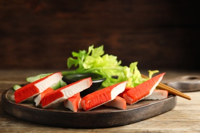 Fresh crab sticks with lettuce served on wooden table