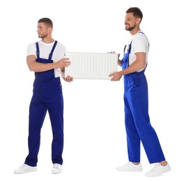 Professional plumbers with new heating radiator on white background