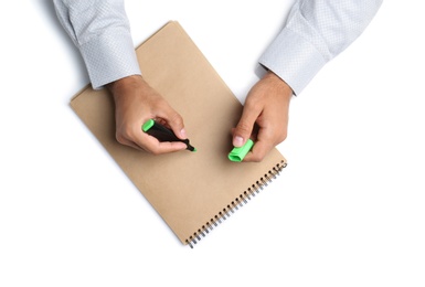 Man with highlighter and notepad on white background, top view. Closeup of hands