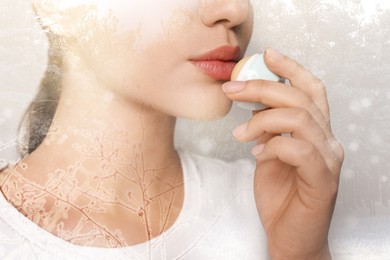 Image of Winter skin care. Closeup of woman applying lip balm, frost effect. Beautiful forest on background