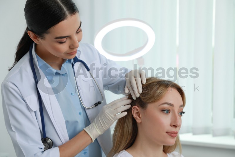 Young woman visiting trichologist in light clinic
