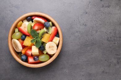 Delicious fruit salad on grey table, top view. Space for text