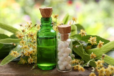 Tincture, bottle of homeopathic remedy and linden flowers on wooden table