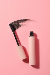 Photo of Mascara for eyelashes and smear on pink background, flat lay. Makeup product