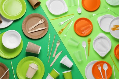 Flat lay composition with plastic and eco disposable tableware on green background