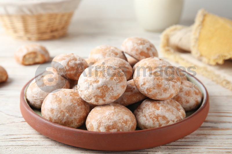 Photo of Plate with tasty homemade gingerbread cookies on white wooden table