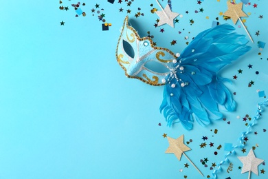 Beautiful carnival mask with decor on light blue background, flat lay. Space for text