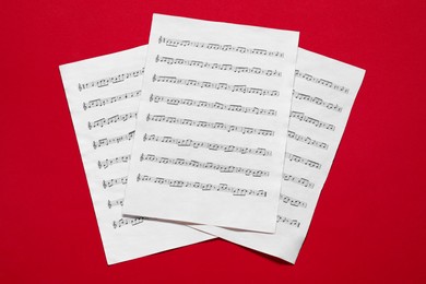 Photo of Note sheets on red background, flat lay