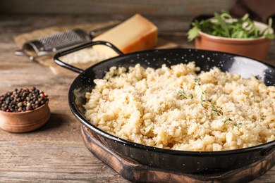 Photo of Delicious risotto with cheese on wooden table, closeup