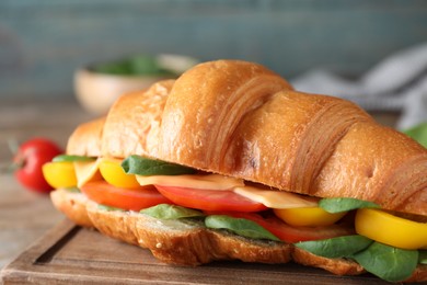 Tasty vegetarian croissant sandwich on table, closeup