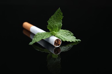 Menthol cigarette and mint on black background