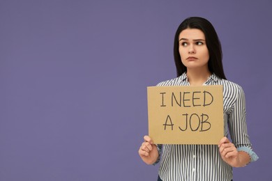 Photo of Unemployment problem. Unhappy woman holding sign with phrase I Need A Job on violet background. Space for text