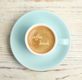 Cup of aromatic espresso with phrase Coffee Break on white wooden table, top view  