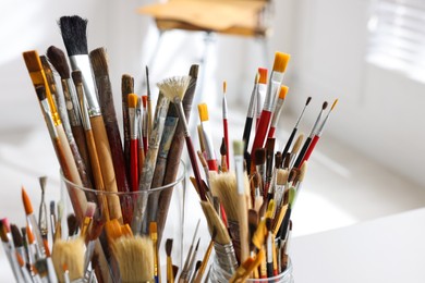 Different paintbrushes on white table indoors, closeup. Artist's workplace