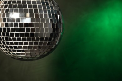 Shiny disco ball on dark background, closeup. Space for text