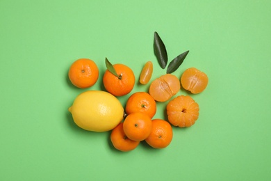 Different citrus fruits on green background, flat lay