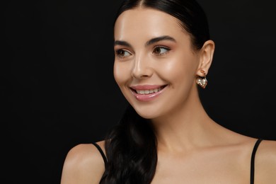 Young woman with elegant pearl earrings on black background, closeup. Space for text