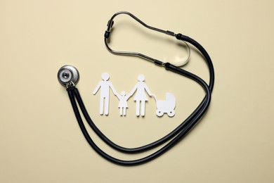 Paper family figures and stethoscope on beige background, flat lay. Insurance concept