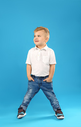 Cute little boy posing on blue background