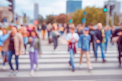 People crossing street in city, blurred view