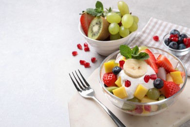 Delicious fruit salad on light table. Space for text