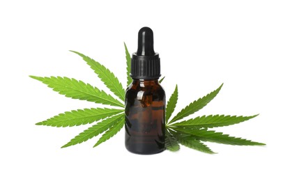 Bottle of CBD oil or THC tincture and hemp leaves on white background