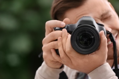 Male photographer with professional camera on blurred background. Space for text