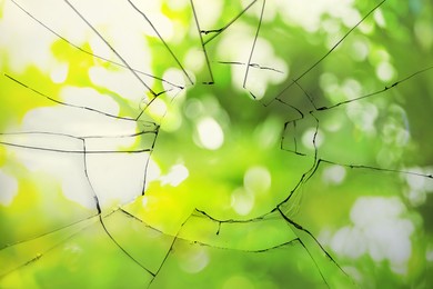 View through broken window on blurred green background