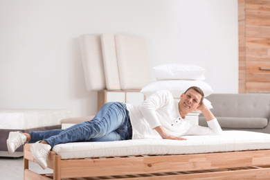 Man testing soft mattress in furniture store