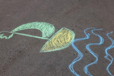 Child's chalk drawing of boat on asphalt