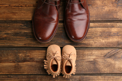 Dad and son's shoes on wooden background, flat lay. Happy Father's Day