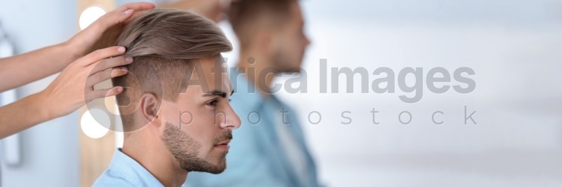 Professional hairdresser working with young man in barbershop. Banner design