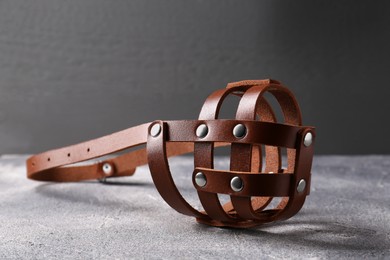 Photo of Brown leather dog muzzle on light gray textured table