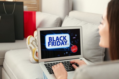 Woman using laptop with Black Friday announcement on screen, closeup