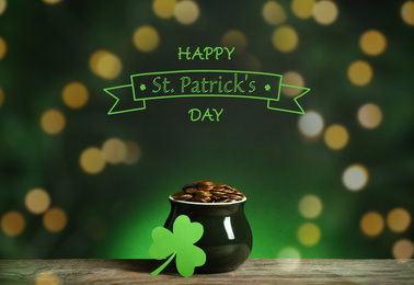 Pot with gold coins and clover on wooden table. Happy St. Patrick's Day