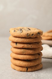 Stack of tasty chocolate chip cookies on grey table