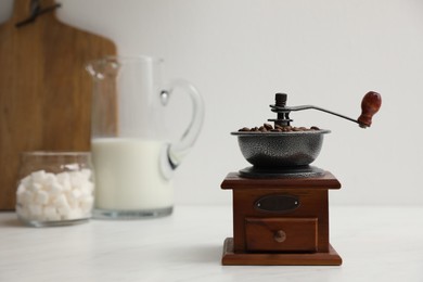 Vintage manual coffee grinder with beans on counter in kitchen