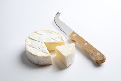 Cut Camembert cheese and knife on white background