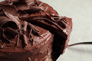 Tasty homemade chocolate cake and shovel on grey table, closeup