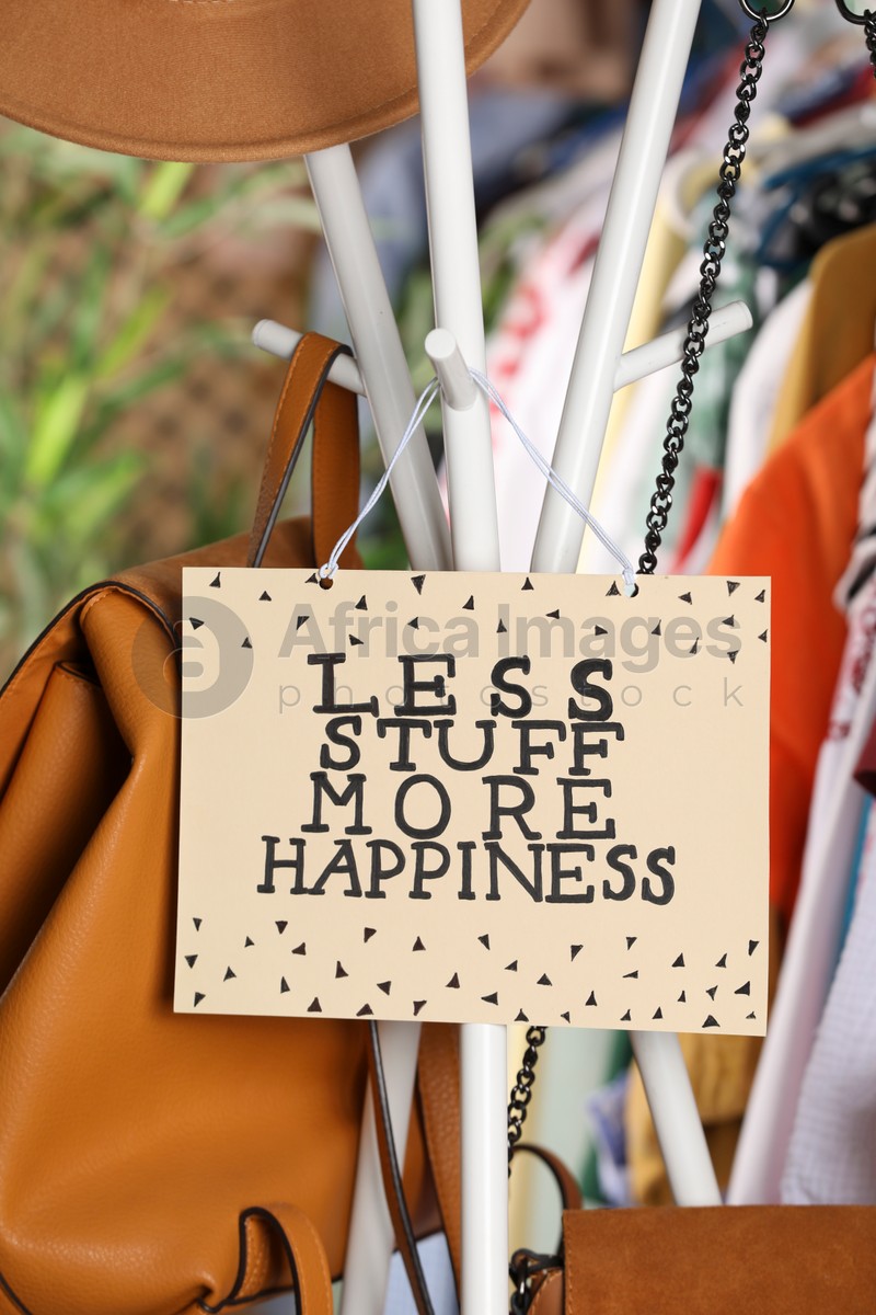 Plate with words Less Stuff More Happiness near bags and clothes