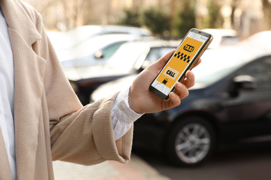 Woman ordering taxi with smartphone on city street, closeup