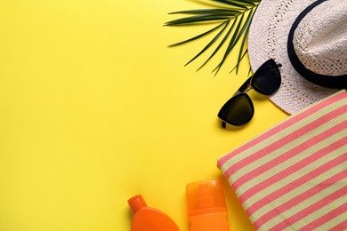 Flat lay composition with different beach objects on yellow background, space for text