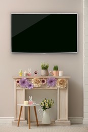Image of Modern wide screen TV and decorative fireplace with beautiful spring decor in room