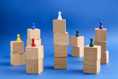 Wooden blocks with color playing pieces on blue background. Roles and responsibility concept