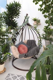 Photo of Comfortable egg chair and beautiful houseplants in room. Lounge zone interior
