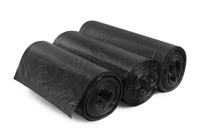 Photo of Rolls of different garbage bags on white background. Cleaning supplies